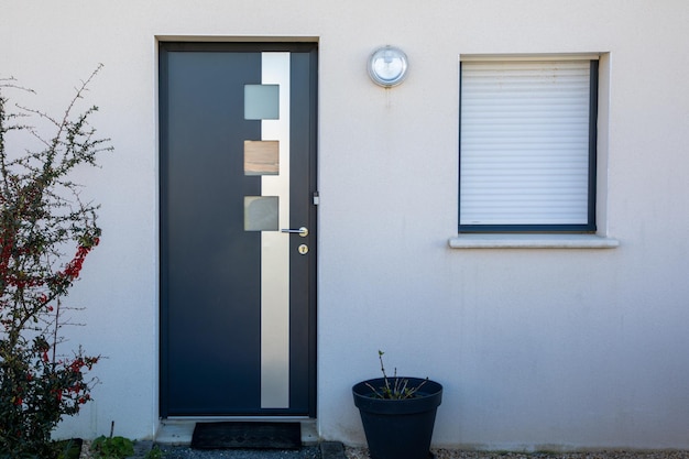 Nuova moderna porta grigia con ingresso in alluminio alla facciata della casa