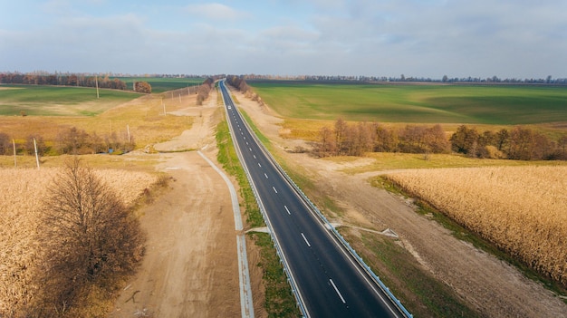 Nuova strada asfaltata lungo la strada dei campi vista dall'aria Fotografia di droni di paesaggi con vista aerea