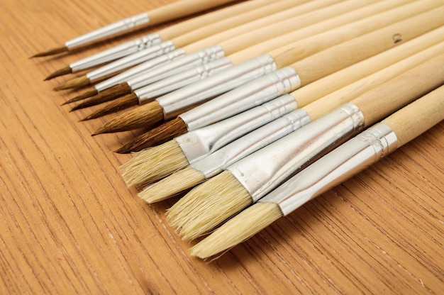 Nuova struttura di set di pennelli in legno diverso su uno sfondo colorato