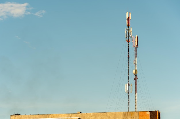 Nuove antenne GSM su un'alta torre contro un cielo blu per la trasmissione di un segnale 5g sono pericolose per la salute Inquinamento da radiazioni dell'ambiente attraverso le torri cellulari La minaccia di estinzione