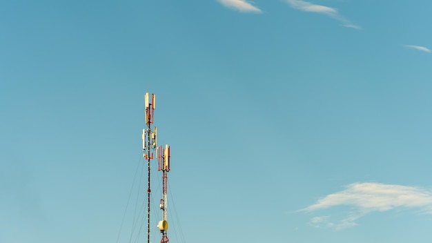 Nuove antenne GSM su un'alta torre contro un cielo blu per la trasmissione di un segnale 5g sono pericolose per la salute Inquinamento da radiazioni dell'ambiente attraverso le torri cellulari La minaccia di estinzione