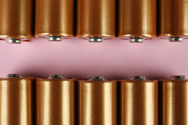 Nuove batterie AA su sfondo rosa piatto