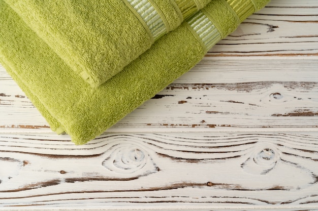 Nuovi asciugamani impilati su un tavolo di legno
