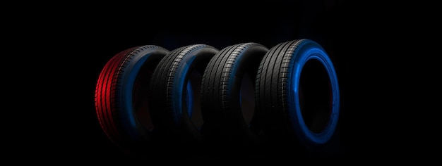 Nuovi pneumatici per auto Gruppo di ruote da strada su sfondo scuro Pneumatici estivi con battistrada asimmetrico Concetto di guida dell'auto