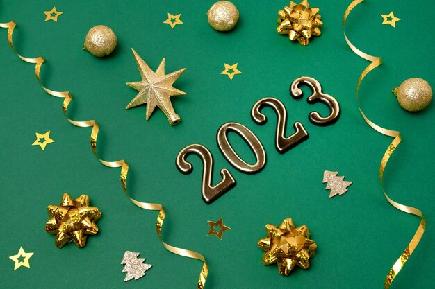 Nuovo anno Sfondo verde Decorazione dorata Biglietto di auguri di Natale Mockup Scintilla Bagattelle Vista dall'alto Copia spazio Palle d'oro Coriandoli su sfondo festivo verde scuro Banner Modello Numeri 2023