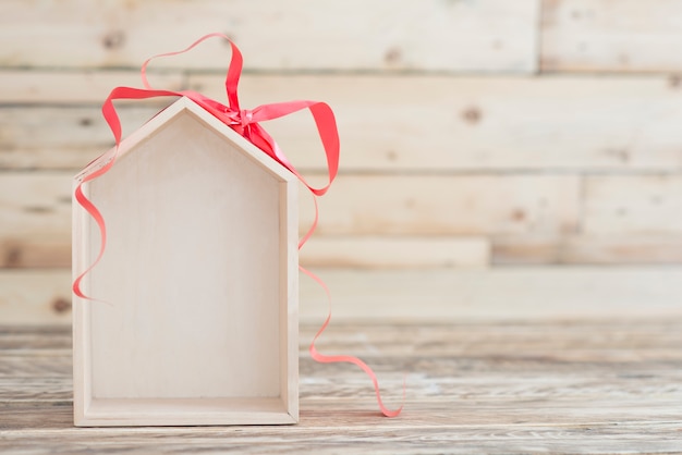 Nuovo concetto di casa sullo sfondo di legno