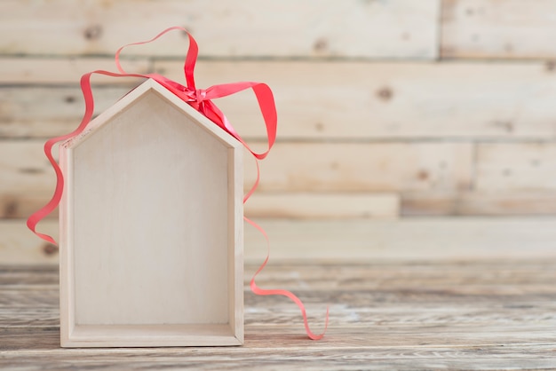 Nuovo concetto di casa sullo sfondo di legno