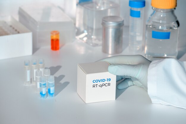 Nuovo kit di test coronavirus COVID-19. Kit diagnostico pcr nCoV 2019. Mano nel guanto con scatola. Il kit RT-PCR rileva il virus covid19 nei campioni dei pazienti. È basato sull'amplificazione PCR in tempo reale.