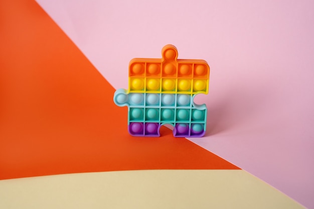 Nuovo popolare giocattolo popit antistress colorato in silicone per bambini sullo sfondo con forme geometriche