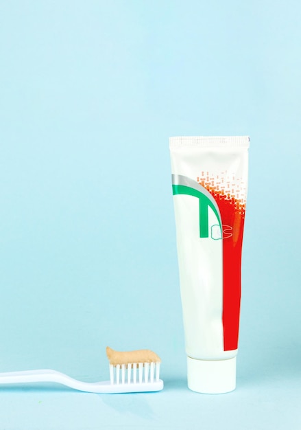 Nuovo spazzolino da denti con dentifricio alzato su sfondo blu Concetto dentale professionale