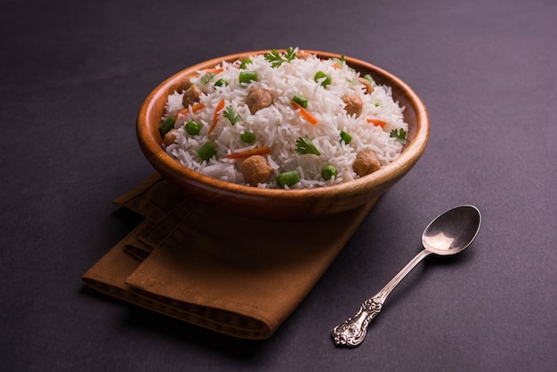 Nutriente pulao di soia o pilaf o riso fritto a pezzi di soia con piselli e fagioli. Servito in una ciotola su sfondo colorato o in legno. Messa a fuoco selettiva