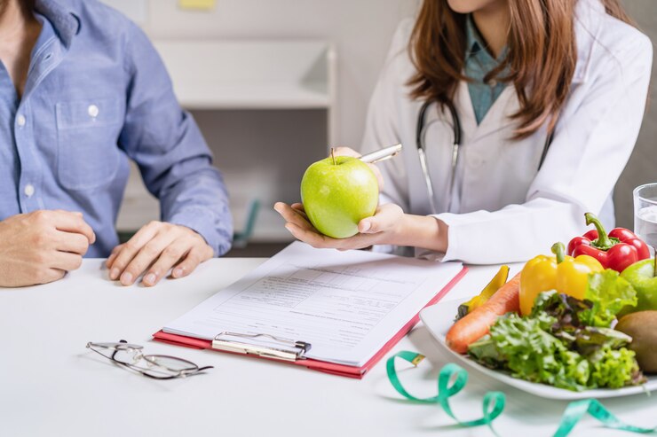 Nutrizionista che dà consultazione al paziente con frutta e verdura sana, giusta nutrizione e concetto di dieta