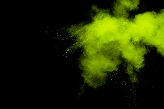 Nuvola di esplosione della polvere di colore verde su fondo nero Spruzzata di polvere verde su fondo.