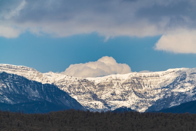 Nuvola sulle cime delle montagne innevate