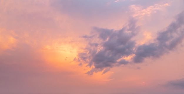 Nuvole lanuginose drammatiche di tramonto dell'oro arancione al paesaggio della natura del cielo rosa della sera