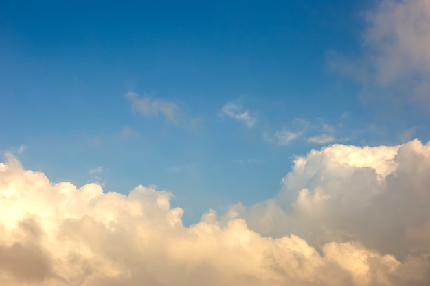 Nuvole morbide e delicate, bianche e gialle contro il cielo azzurro nella parte inferiore del fotogramma.