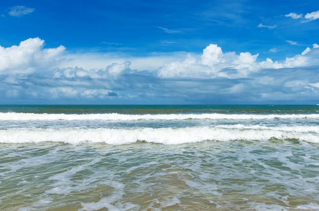 Nuvole su cielo blu sopra il mare calmo con la riflessione di luce solare