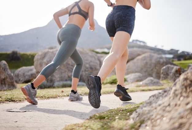 Obiettivi di amicizia e fitness. Inquadratura posteriore di due donne che vanno a correre in un parco.