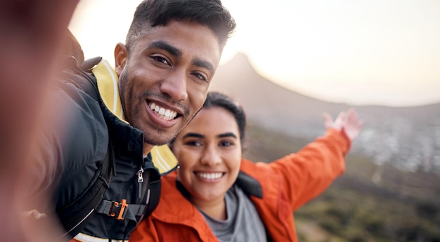 Obiettivi di coppia. Ritratto ritagliato di una giovane coppia affettuosa che si fa selfie mentre fa un'escursione in montagna.