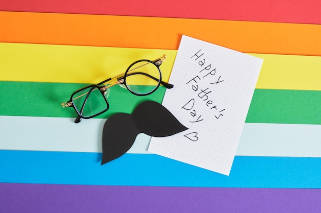Occhiali creativi con diverse forme di lenti e baffi di carta su sfondo colorato arcobaleno spazio copia