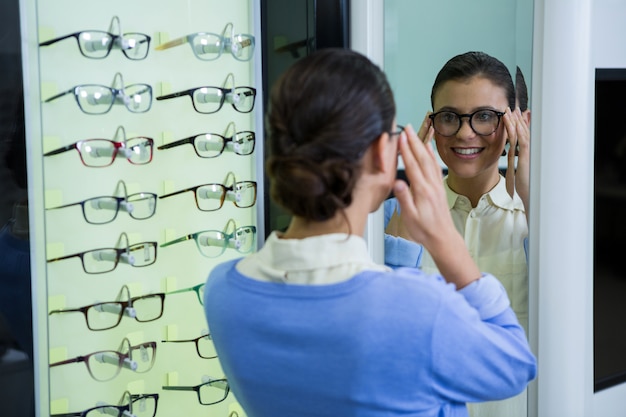 Occhiali d'uso del cliente femminile e controllare specchio