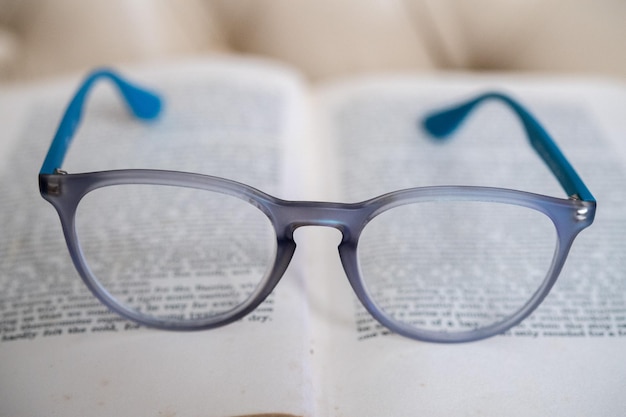 Occhiali da lettura azzurri isolati su un libro