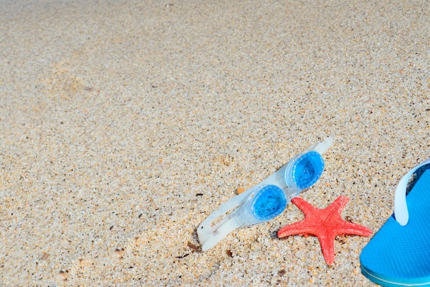 Occhiali da mare stelle marine e sandali in riva al mare