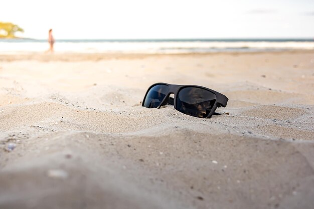 Occhiali da sole sulla sabbia concetto di vacanza estate tropicale in brasile sulla spiaggia