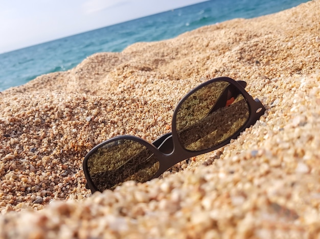 Occhiali da sole sulla spiaggia di sabbia