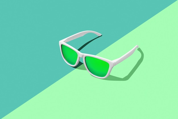 Occhiali da sole verdi su sfondo verde. Studio shot di occhiali da sole con copia spazio.