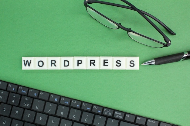 Occhiali da tastiera per laptop e penna con parole alfabetiche Wordpress Concetto Wordpress