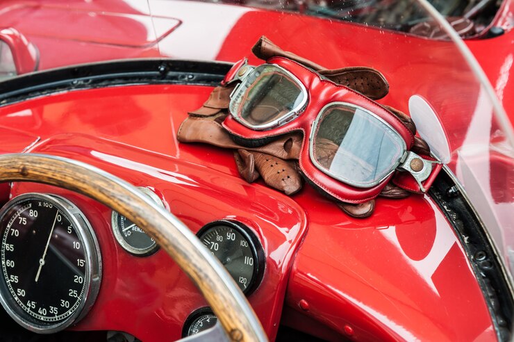 Occhiali e guanti all'interno di un'auto rossa d'epoca