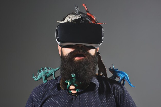 Occhiali per realtà virtuale. Uomini che usano le cuffie per realtà virtuale. Dispositivo di realtà virtuale. periodo giurassico. Uomini con dinosauri giocattolo.