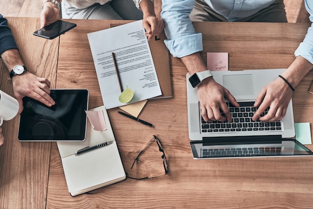 Occupato a lavorare. Primo piano vista dall'alto di giovani colleghi moderni che lavorano insieme