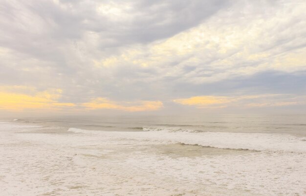 Oceano Atlantico con le onde che si schiantano e fanno le bolle di schiuma d'acqua e d'aria bianca al tramonto