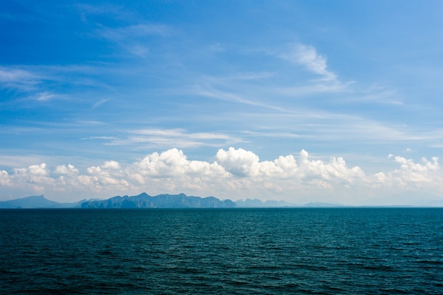 Oceano blu con cielo nuvoloso