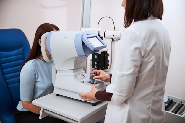 Oculista che controlla la vista della donna su un apparecchio