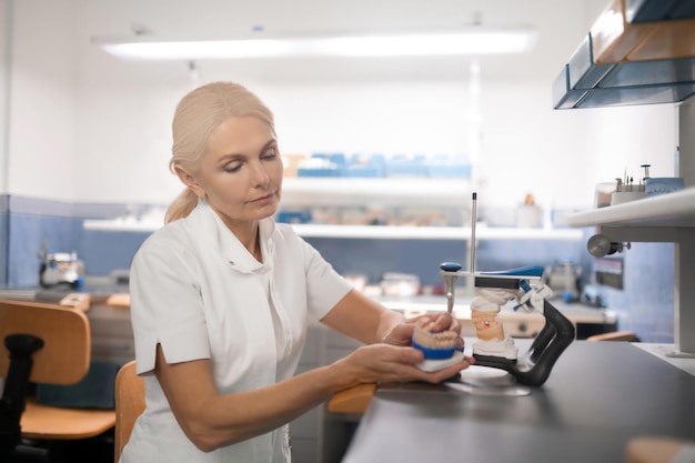 Odontotecnico alla ricerca di problemi nel modello fuso dei denti