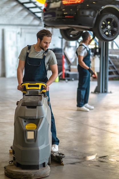 Officina riparazioni auto. Tecnici che lavorano in un'officina di riparazioni auto e sembrano occupati