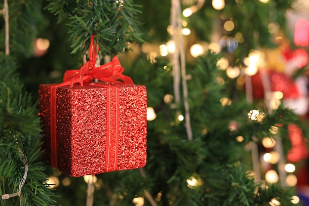 Oggetti decorativi di Natale con la luce per lo sfondo di Natale. Albero di pino con scatola regalo rosso.