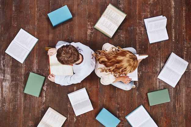 Oggi un lettore domani un leader bambini seduti vicino ai libri mentre leggono tengono in mano dei libri