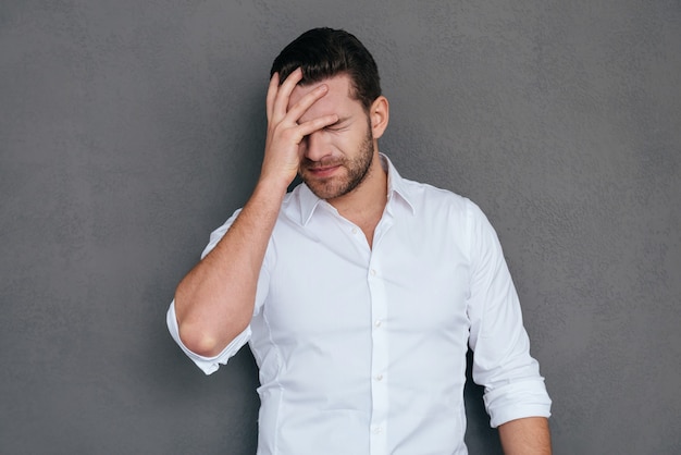 Oh no! Giovane frustrato che copre il viso con la mano e tiene gli occhi chiusi