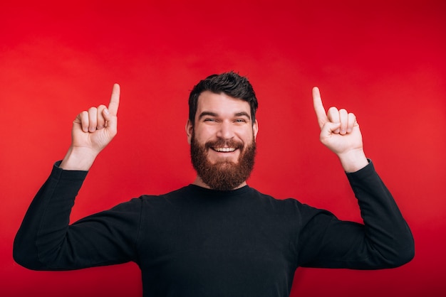 Oh, questa offerta Bell'uomo che punta verso l'alto con entrambe le mani sul muro rosso.