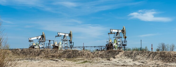 Oil pump jack on a oil field. Summer blue sky background. Extraction of oil. Petroleum concept.
