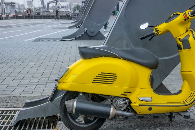 Olanda. Molo dei traghetti per il centro di Amsterdam. Scooter giallo su un enorme supporto di ferro