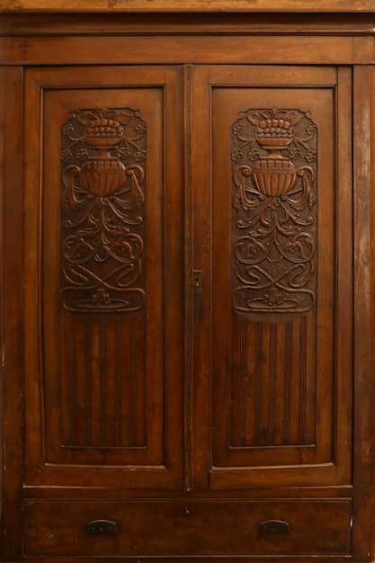 Old vintage wardrobe furniture with ornamental doors and retro colors of wooden surfaces