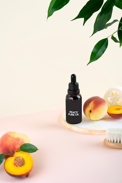 Olio cosmetico dai semi di pesca in una bottiglia di vetro su sfondo rosa Pelle sana capelli viso e corpo cura SPA e concetto di benessere selfcare