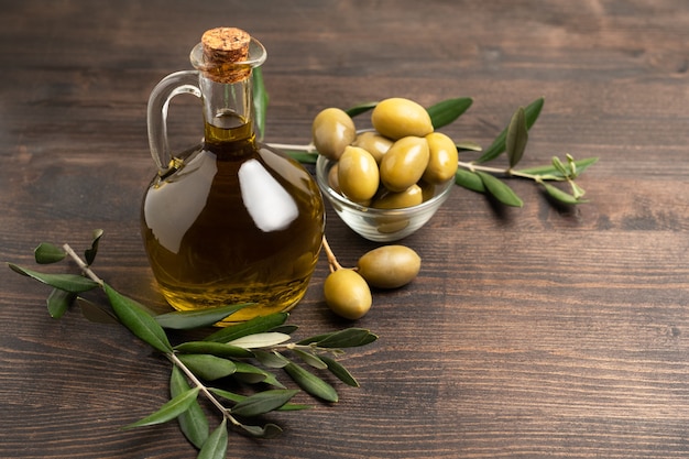 Olio d'oliva in bottiglia e olive verdi