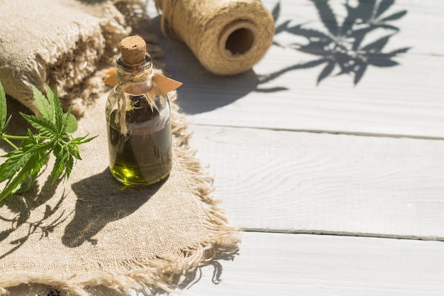 Olio di canapa, tela e fili su una superficie di legno bianca