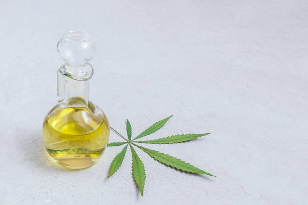 Olio di cannabis CBD in bottiglia di vetro con foglia di marijuana